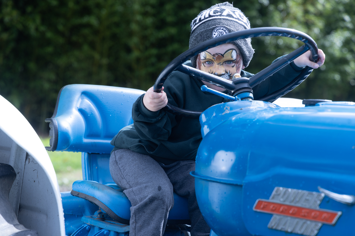 Face painted youngster takes the vintage power major for a drive